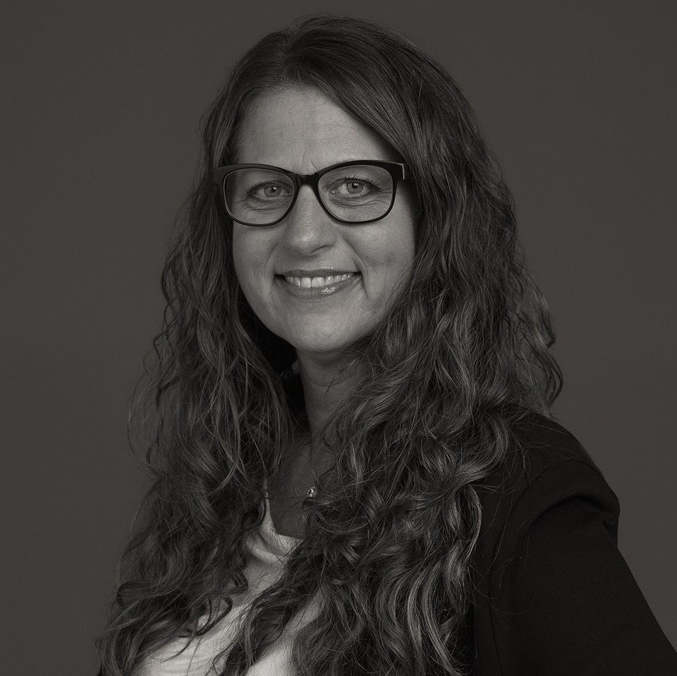 Kvinne med mørkt krøllete hår og briller