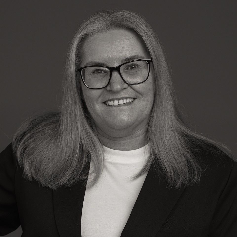 smilende kvinne med blondt hår og briller