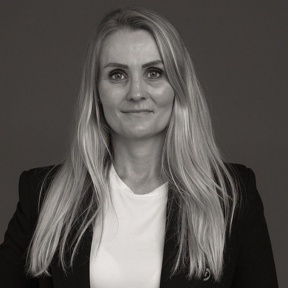 Kvinne med lyst langt hår og dressjakke